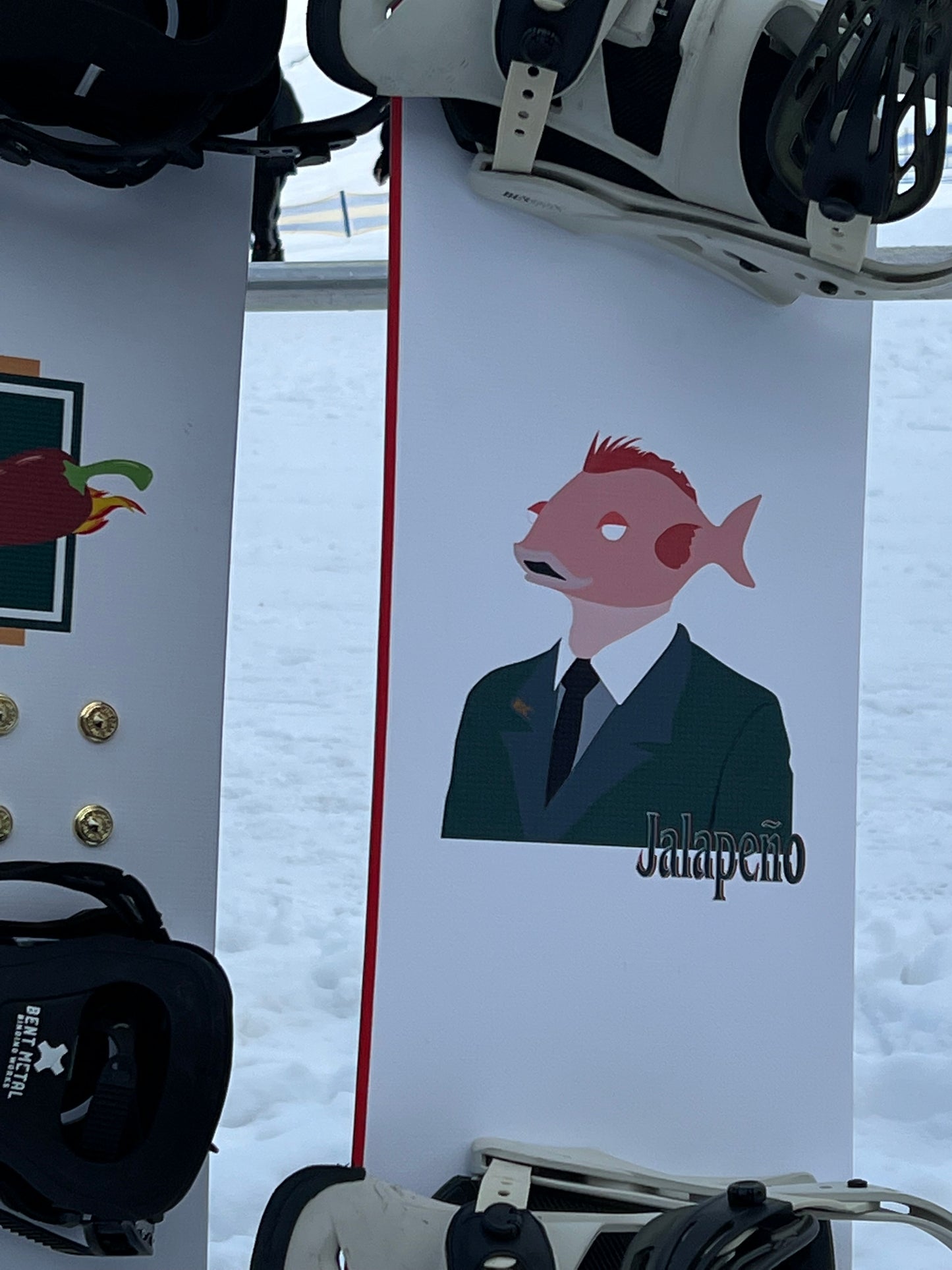 Top Sheet graphic of Sakana custom powder shape snowboard on hill at Front valley Perisher - Jalapeño Board Company