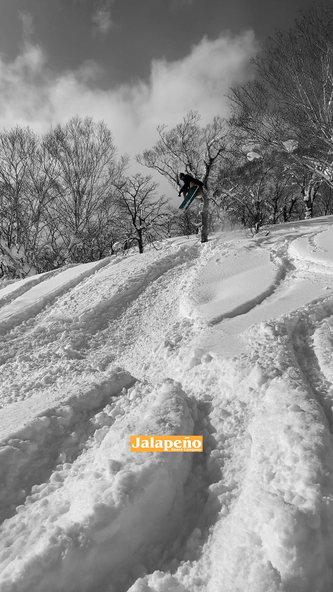 snowboarder riding custom jalapeno board company powder snowboard in niseko